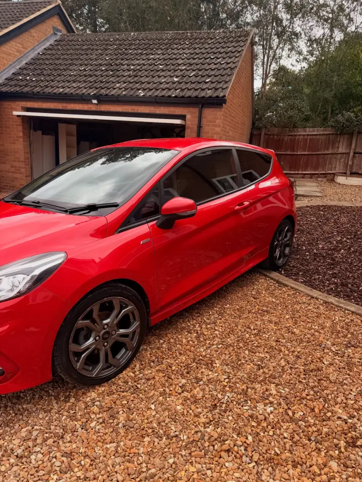 Red Ford Fiesta ST detailed on a gravel driveway